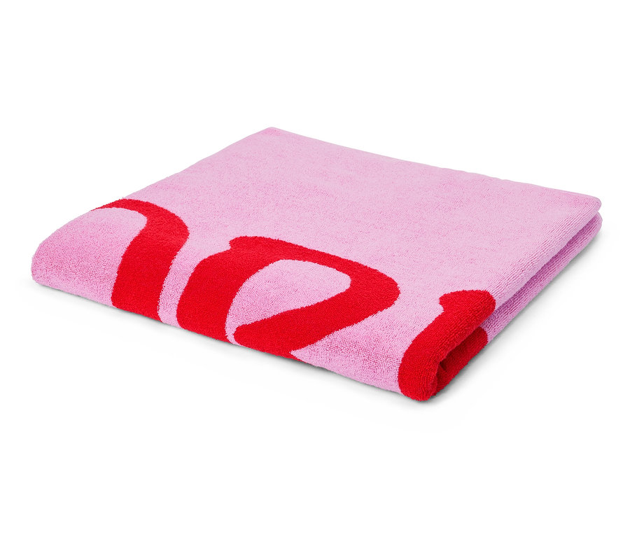 Une serviette rose clair pliée avec un lettrage rouge imprimé est posée sur un fond blanc.