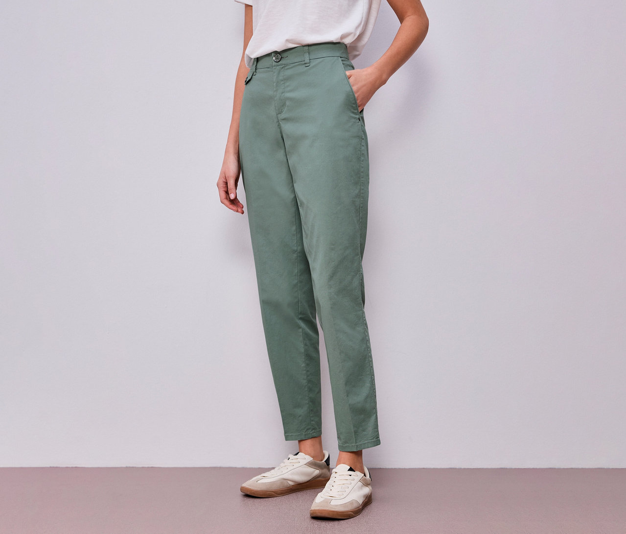 Femme portant un chino menthe Street One et un t-shirt blanc, une main dans la poche.