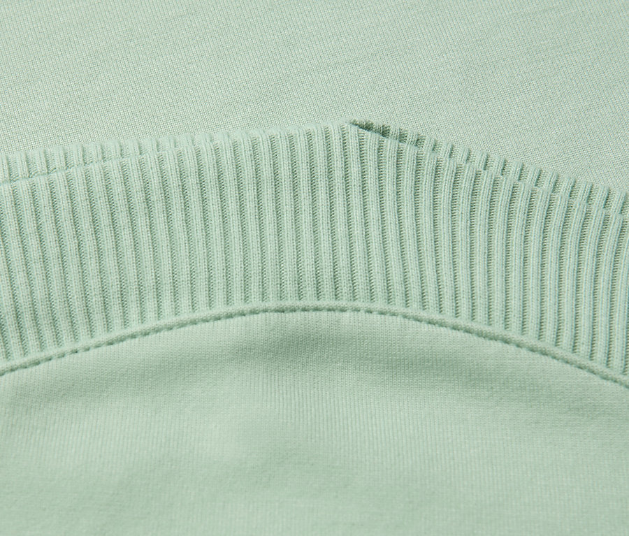 Gros plan d'un t-shirt vert sauge Street One avec des détails côtelés.