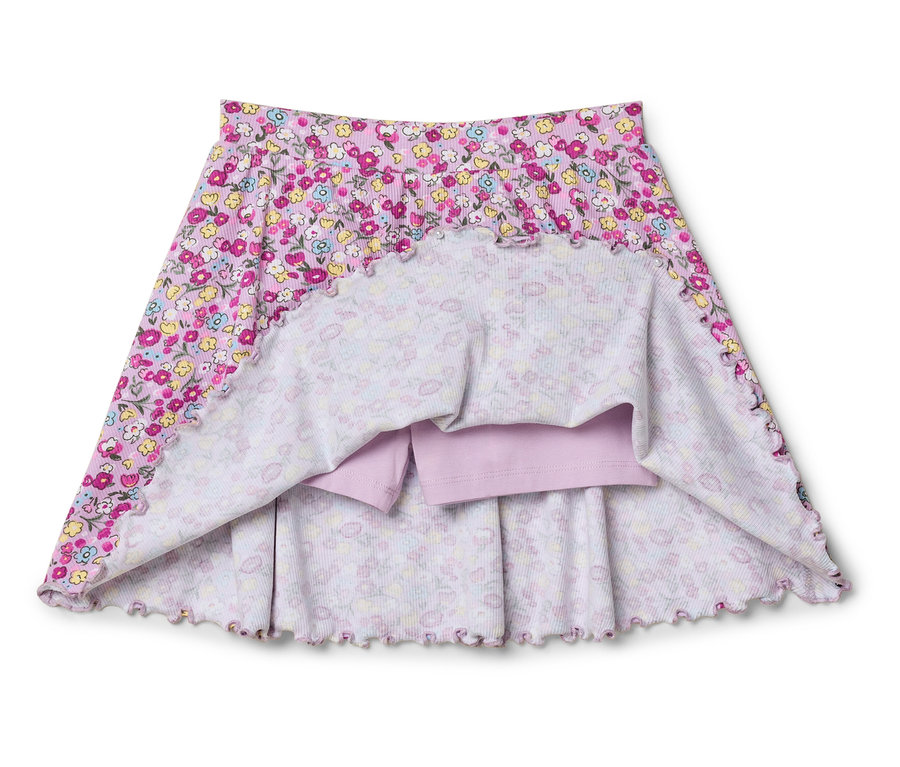 Gros plan d'une jupe rose pour enfants avec un motif floral et un short lilas intégré.