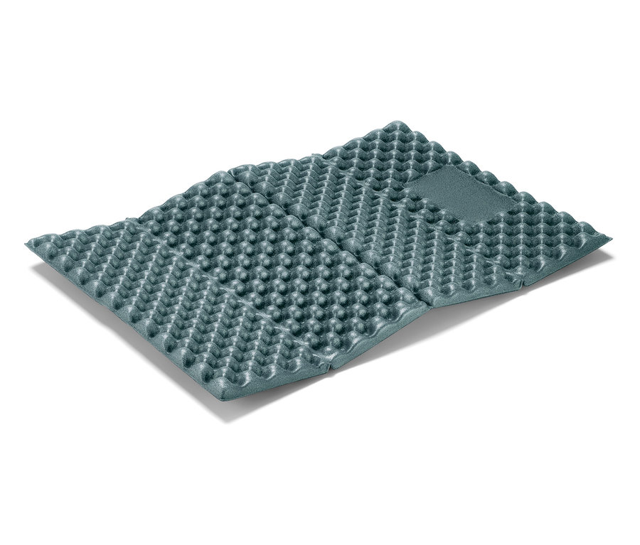 Un tapis de sol gris plié sur un fond blanc.