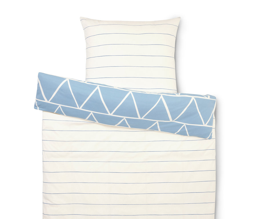 Ensemble de literie avec des rayures blanches et bleues, une taie d'oreiller et un rouleau bleu avec des triangles blancs.
