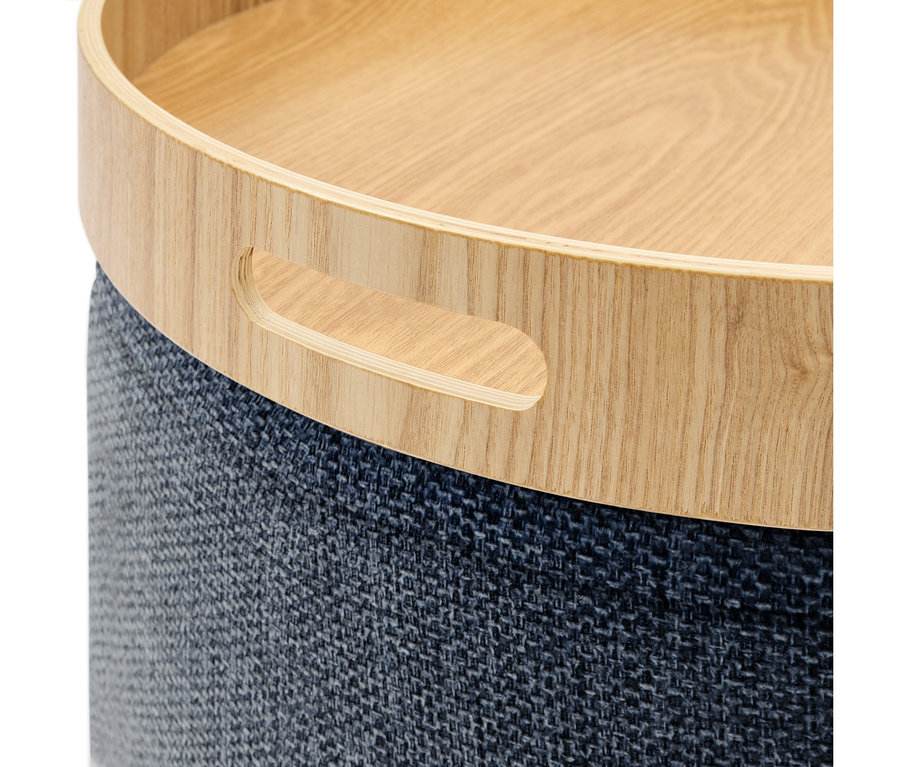 Meuble rond avec un plateau en bois clair et une base en tissu texturé bleu foncé. Le plateau en bois est doté d'une poignée découpée.