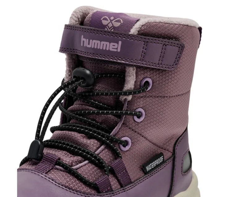 Gros plan d'une botte de neige hummel® « Snow Boot Tex » prune, avec doublure duveteuse, lacets élastiques noirs avec stoppeur, sangle auto-agrippante et étiquette « WATERPROOF ».