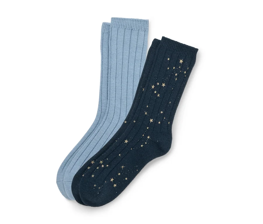 Deux chaussettes côtelées, une bleu clair et une bleu foncé avec un motif d'étoiles dorées, légèrement superposées sur un fond blanc.