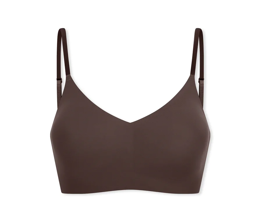 Une brassière bralette marron foncé, sans coutures et sans armatures, avec de fines bretelles réglables et un décolleté en V.