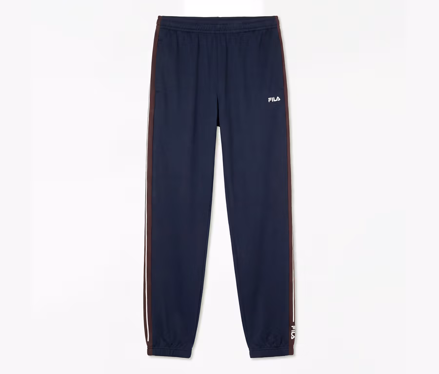 Pantalon de sport FILA pour homme bleu foncé avec chevilles élastiques et une bande rouge et blanche sur les côtés.