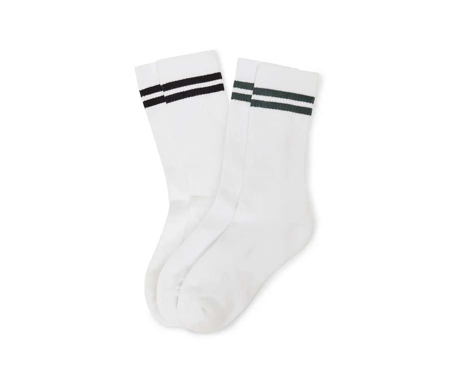 Deux paires de chaussettes blanches, l'une à rayures noires et l'autre à rayures vert foncé, posées côte à côte.