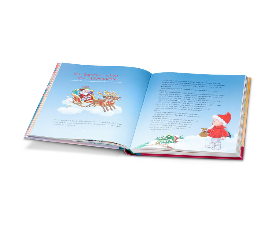 Un livre ouvert illustre le Père Noël avec des rennes dans un traîneau et un garçon en rouge. Le livre « Weihnachten mit meinen Kinderbuch-Helden » (« Noël avec mes héros de livres pour enfants ») est visible.