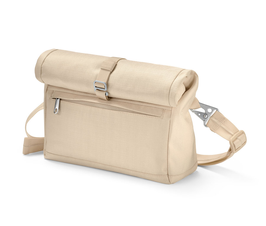 Un sac à bandoulière de sécurité beige enroulé sur le dessus et fermé par une boucle argentée.