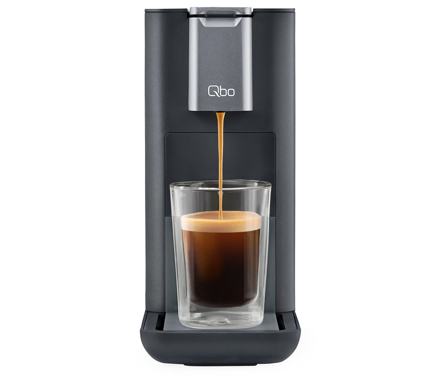 Café coulant d'une machine à café Qbo ESSENTIAL Dark Stone dans un verre.