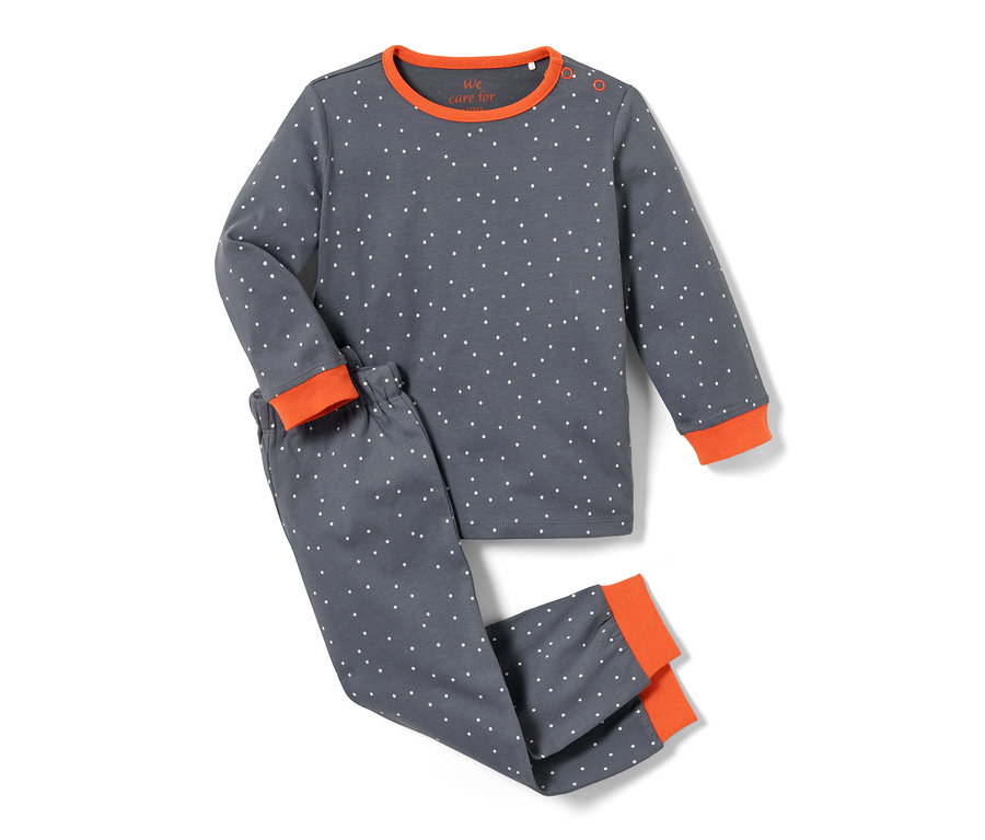Un ensemble de deux pyjamas pour tout-petits, rose et bleu, avec un motif à pois et des bordures orange.