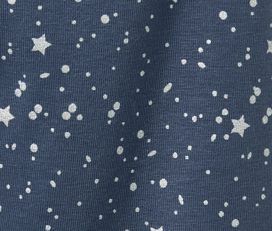 Gros plan sur 2 leggings scintillants pour enfant avec un motif d'étoiles et de points.