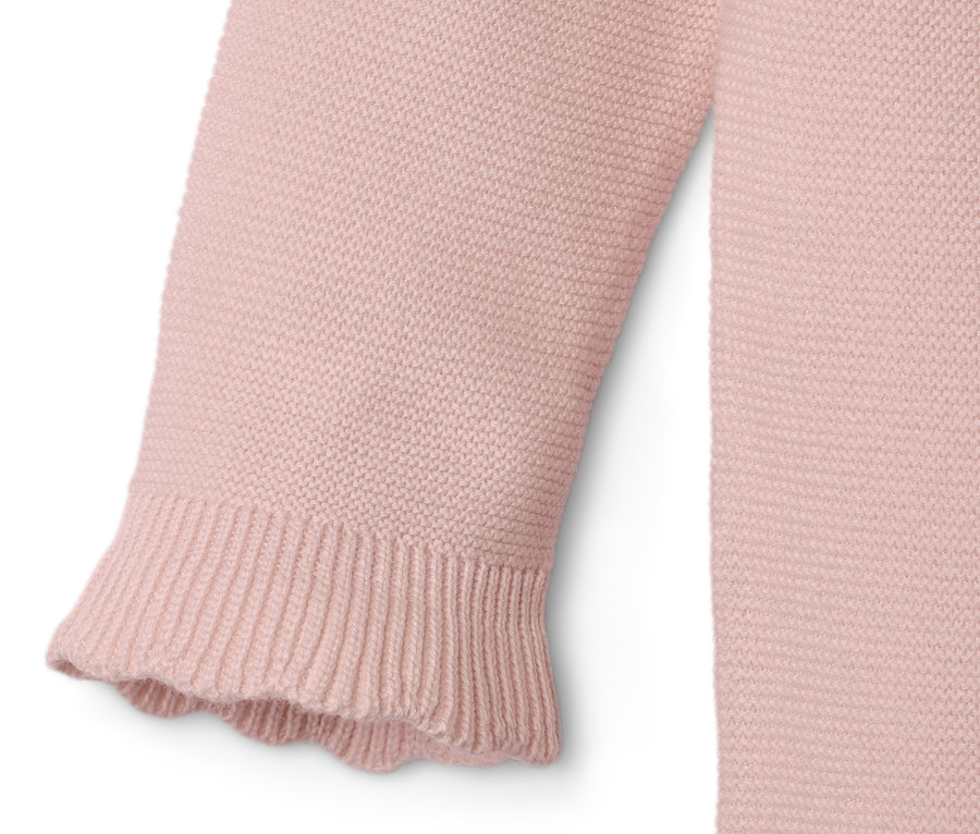 Détail d'une combinaison en maille pour bébé.