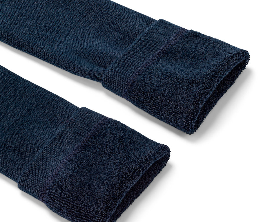 Gros plan sur deux extrémités de leggings thermiques bleus pour enfants.