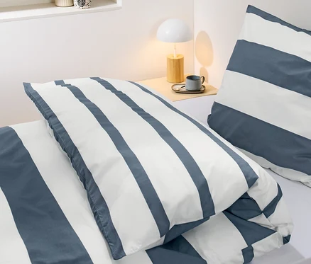 Gros plan d'une parure de lit en percale rayée de taille standard sur un lit.