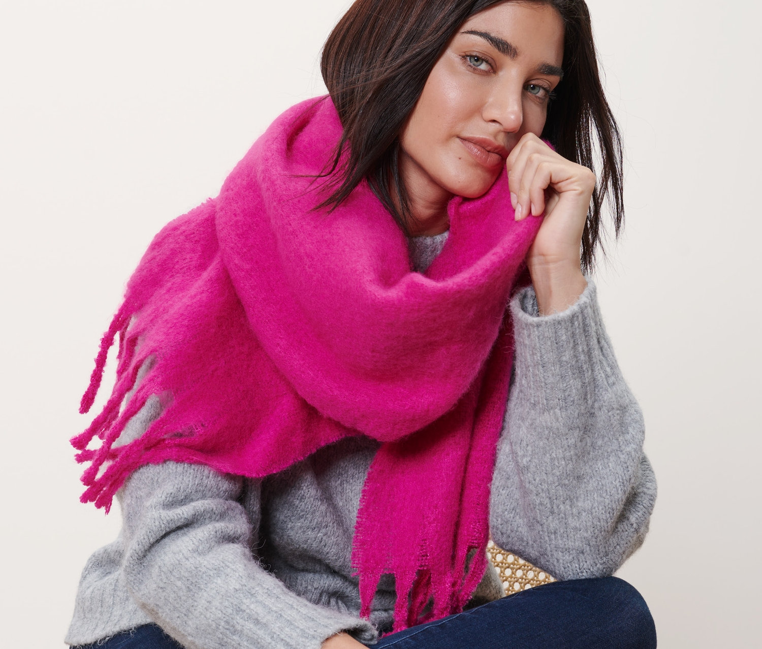 Femme assise portant une écharpe tissée.