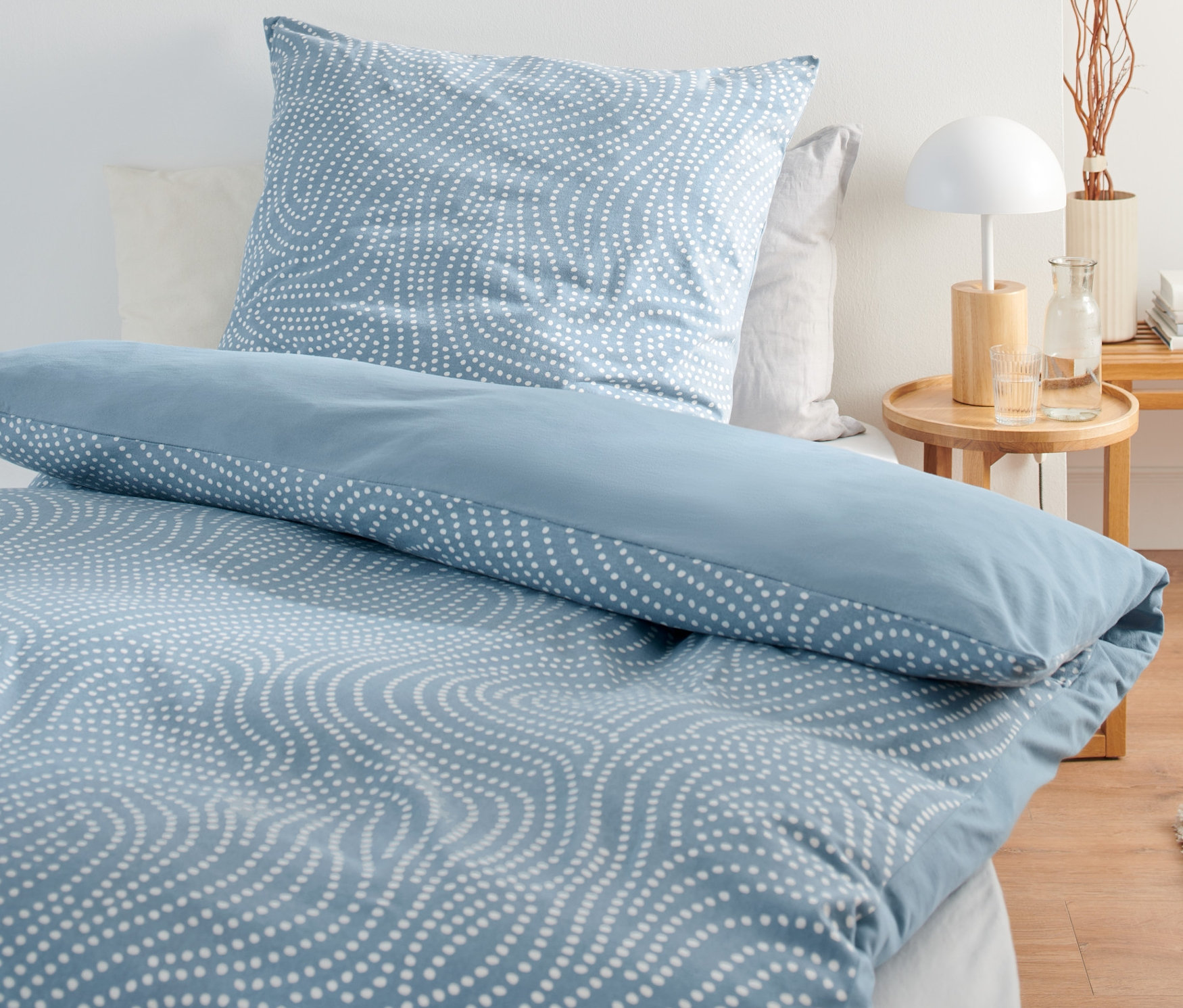 Parure de lit en jersey hivernal de taille standard avec un motif ondulé bleu sur un lit.