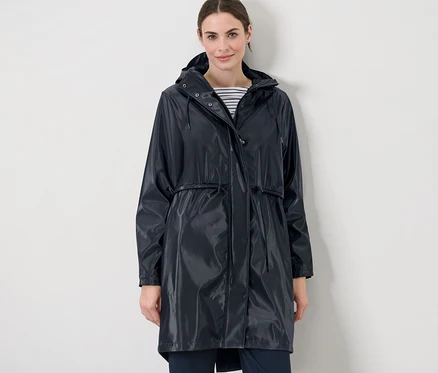 Femme portant un manteau de pluie avec effet brillant.