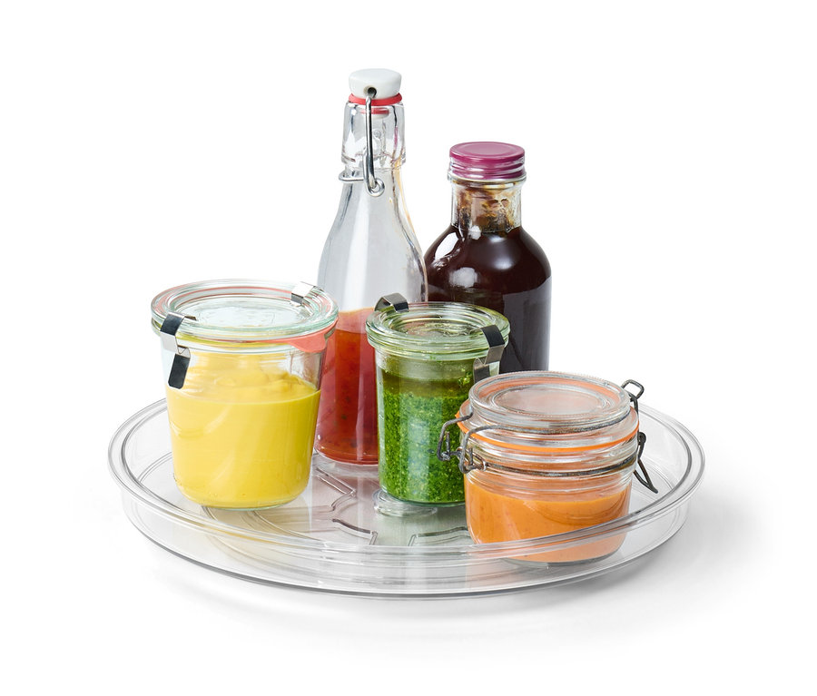 Plateau pivotant avec différents pots en verre et bouteilles contenant des sauces colorées.