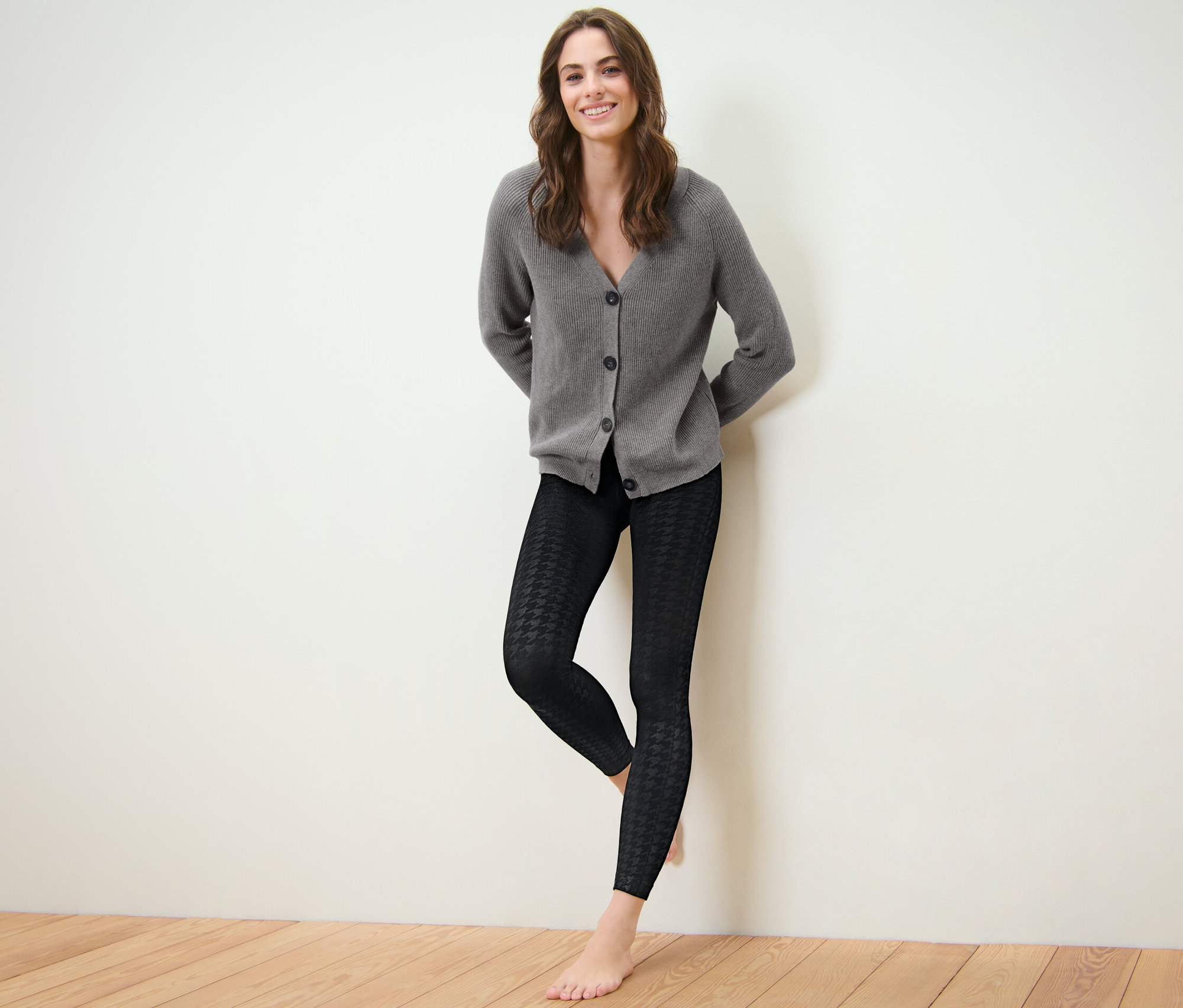 Femme posant en legging thermique avec relief et cardigan gris.