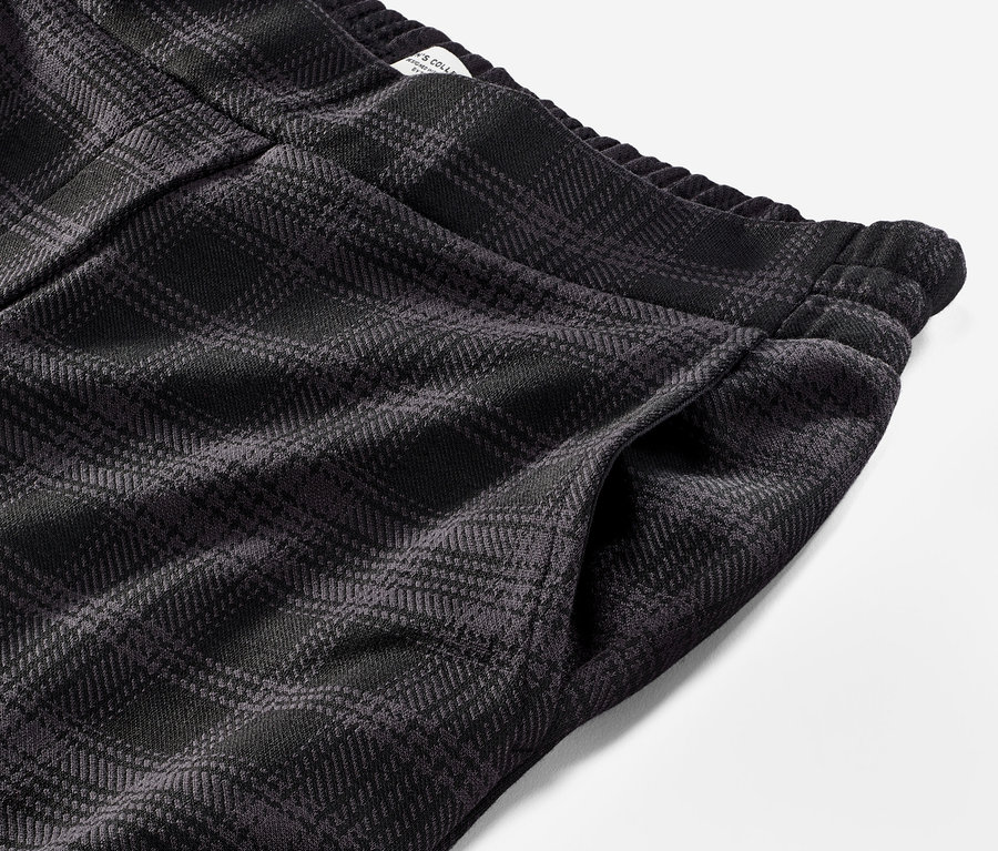 Détail d'un pantalon de jogging à carreaux.
