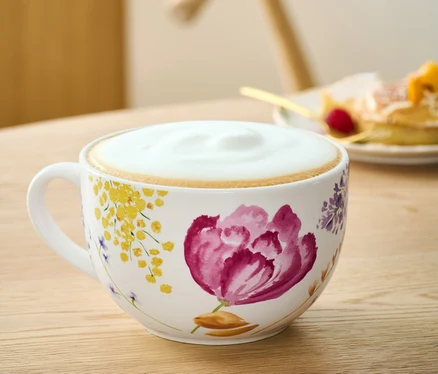 Un bol à café au lait à motifs floraux sur une table.