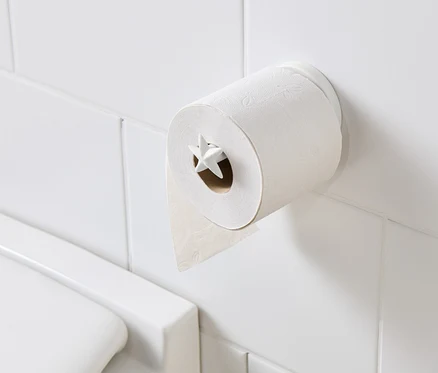 Porte-papier toilette avec papier toilette sur des carreaux blancs.
