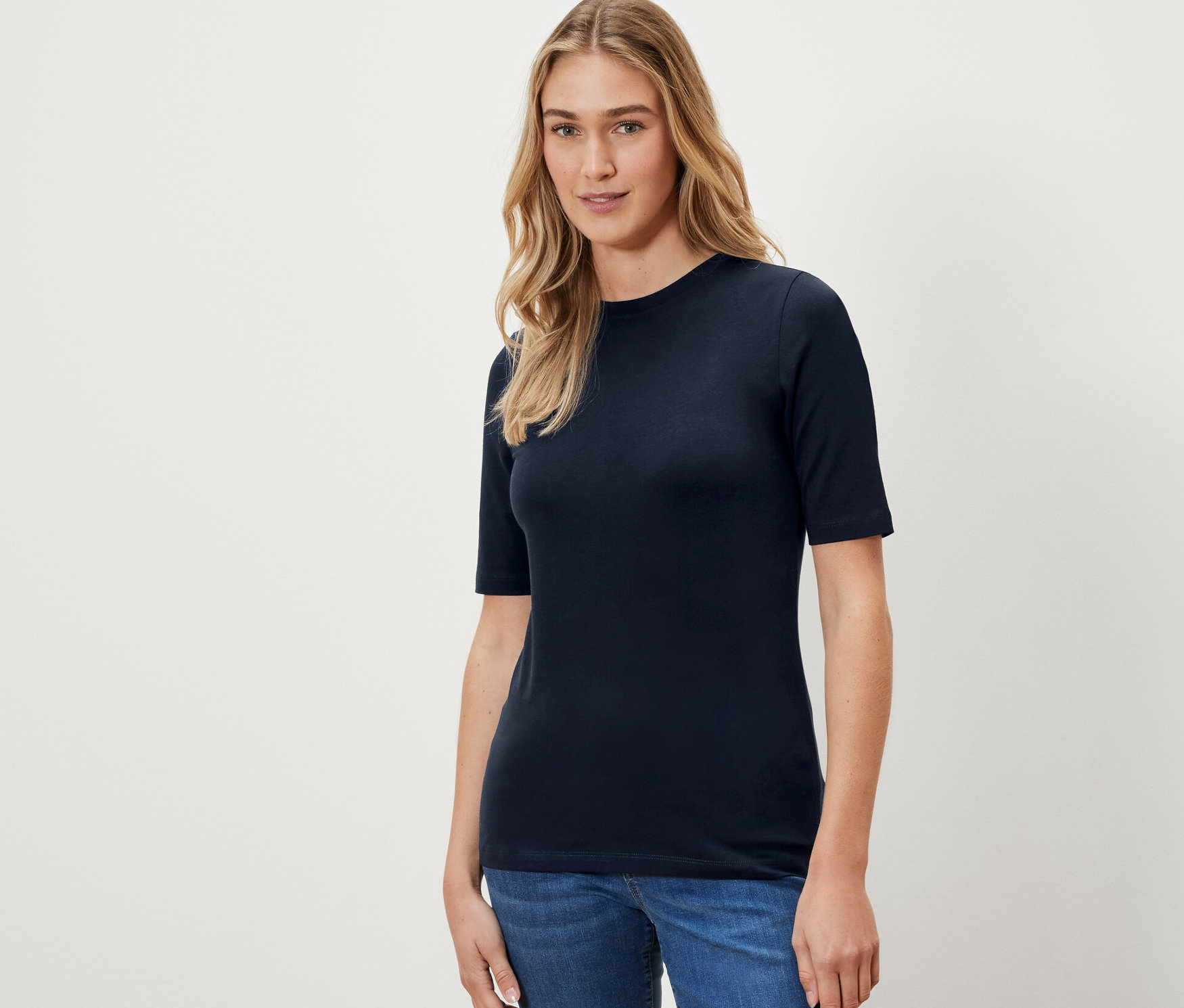 Femme portant un t-shirt demi-manches bleu foncé.