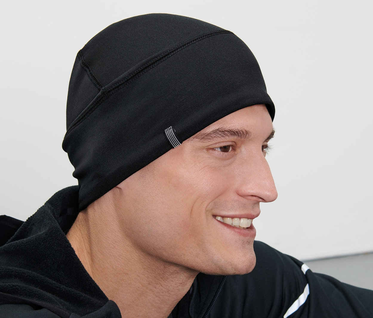 Un homme porte un bonnet thermique noir.