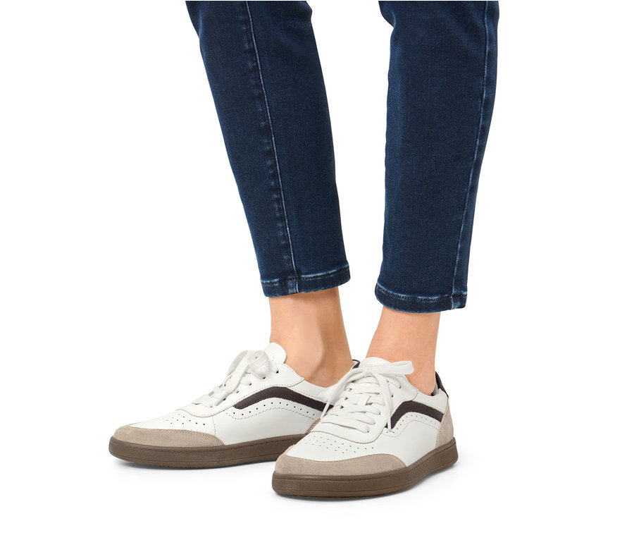 Jambes en jean et baskets en cuir.