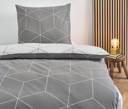 Parure de lit en renforcé grise de taille normale avec un motif géométrique sur un lit.