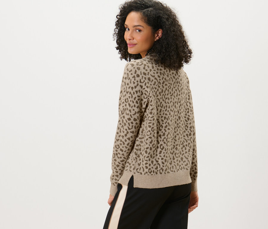 Femme regardant par-dessus son épaule portant un pull en maille imprimé.