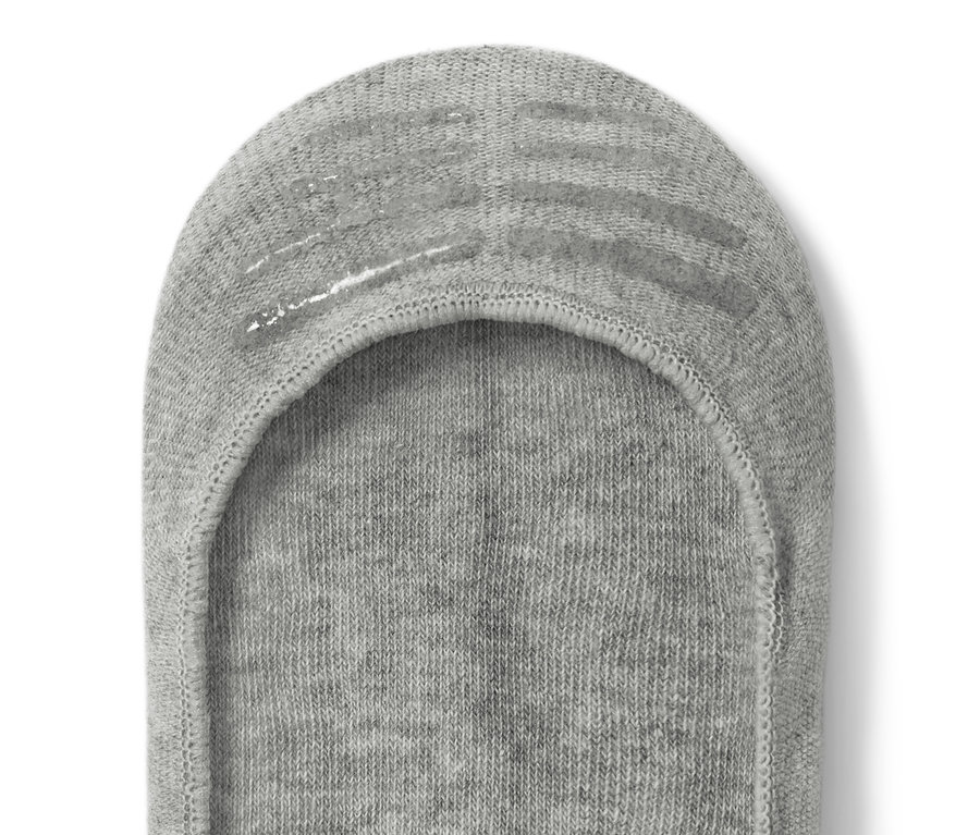Gros plan sur une socquette de sneaker grise.