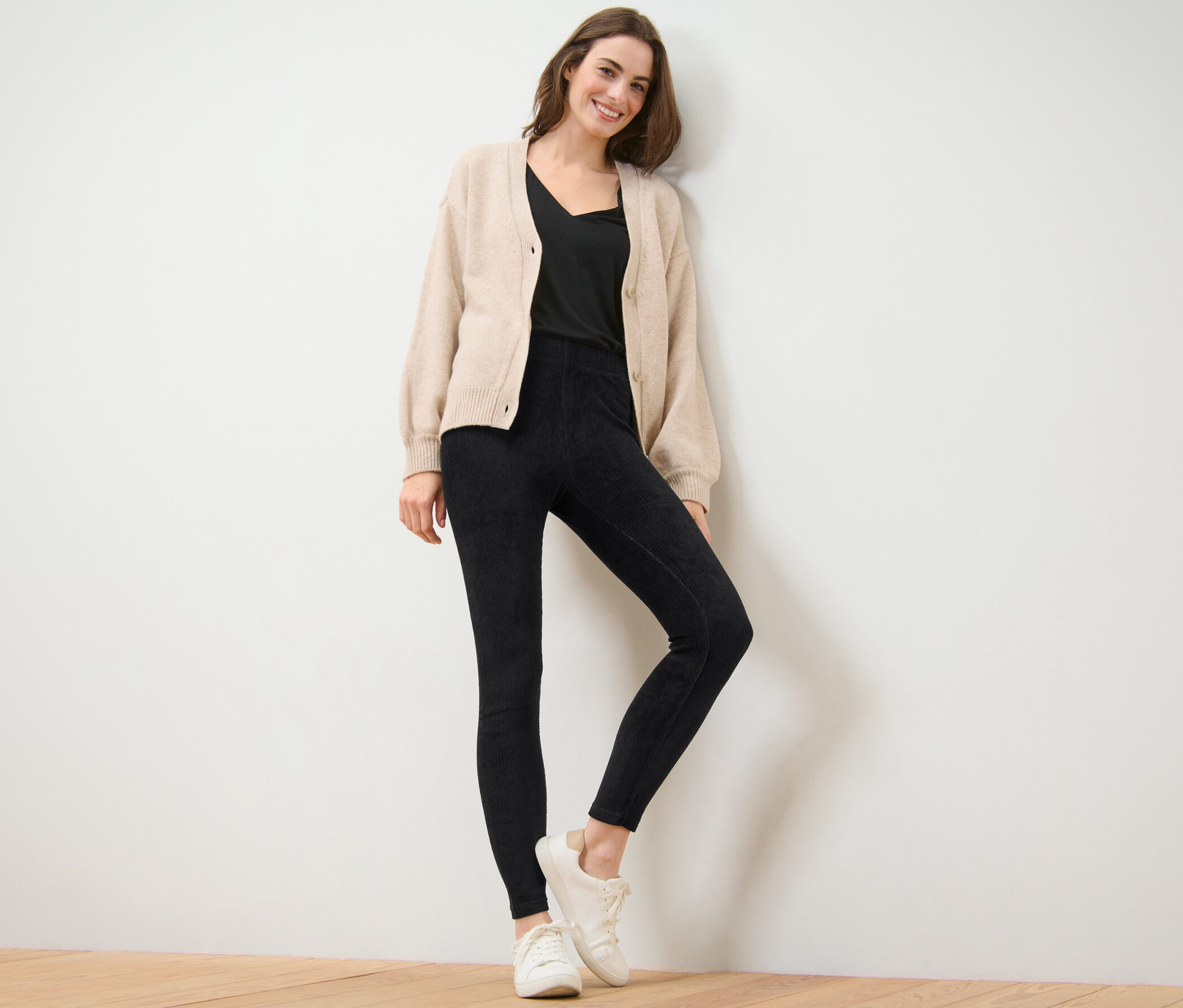 Femme posant en legging en velours côtelé noir.
