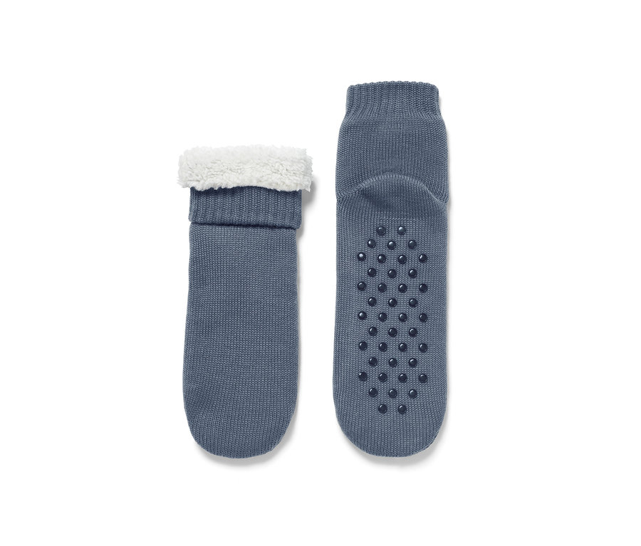 Deux paires de chaussons-chaussettes bleu-gris avec bordure en fourrure blanche et semelle antidérapante.