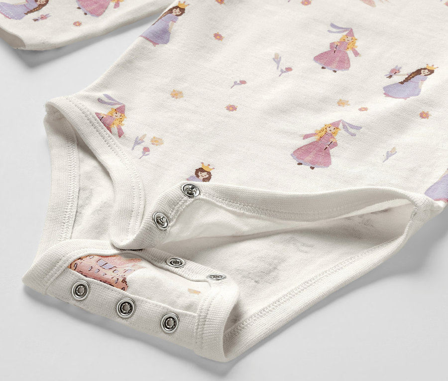 Gros plan sur un body évolutif pour bébé avec un motif de princesses.