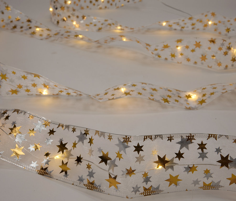 Trois rubans avec des lumières LED et des étoiles sur un fond blanc.