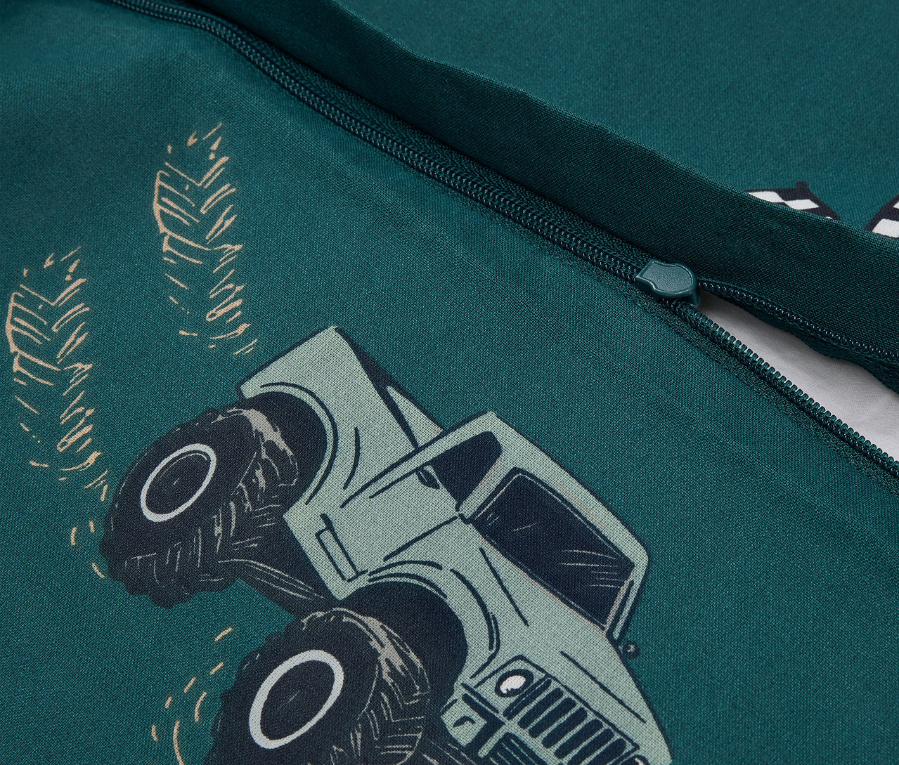 Détail d'une parure de lit enfant renforcé verte avec motif de camion.