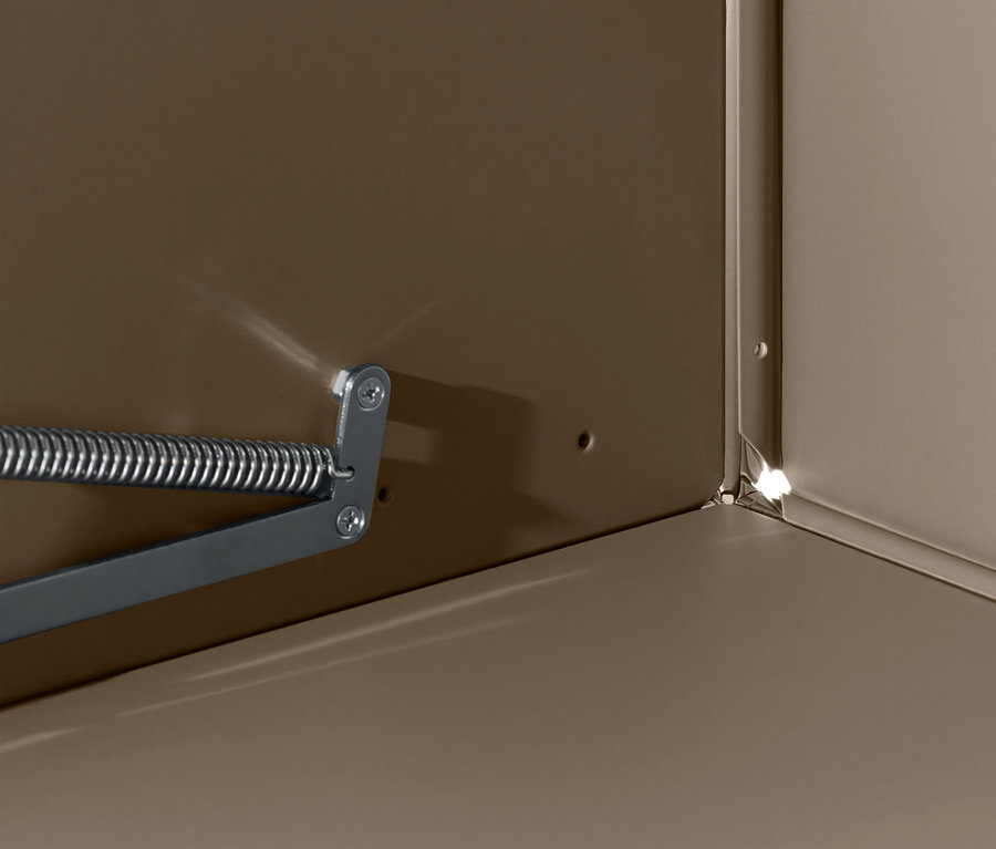 Détail de l'intérieur d'une armoire avec un mécanisme de ressort sur le mur.