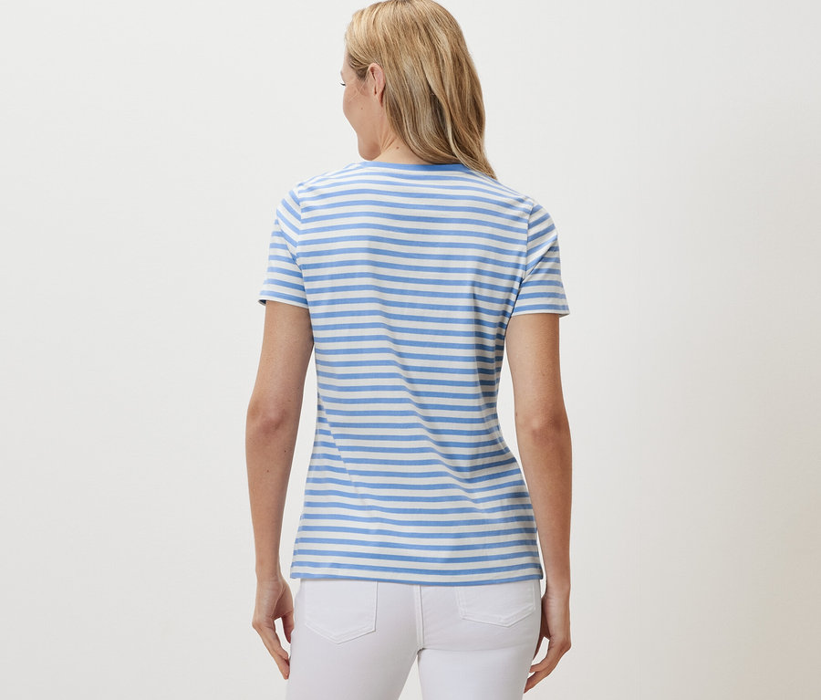 Vue arrière d'une femme blonde portant un t-shirt basique bleu clair et blanc rayé.