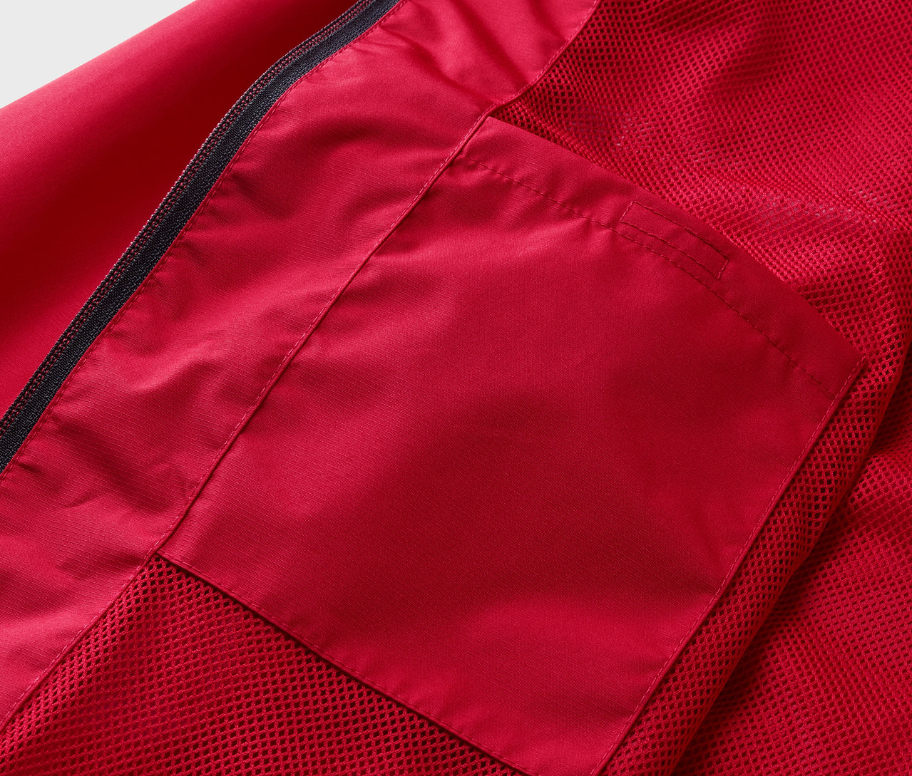 Gros plan sur une veste de pluie rouge avec une poche.