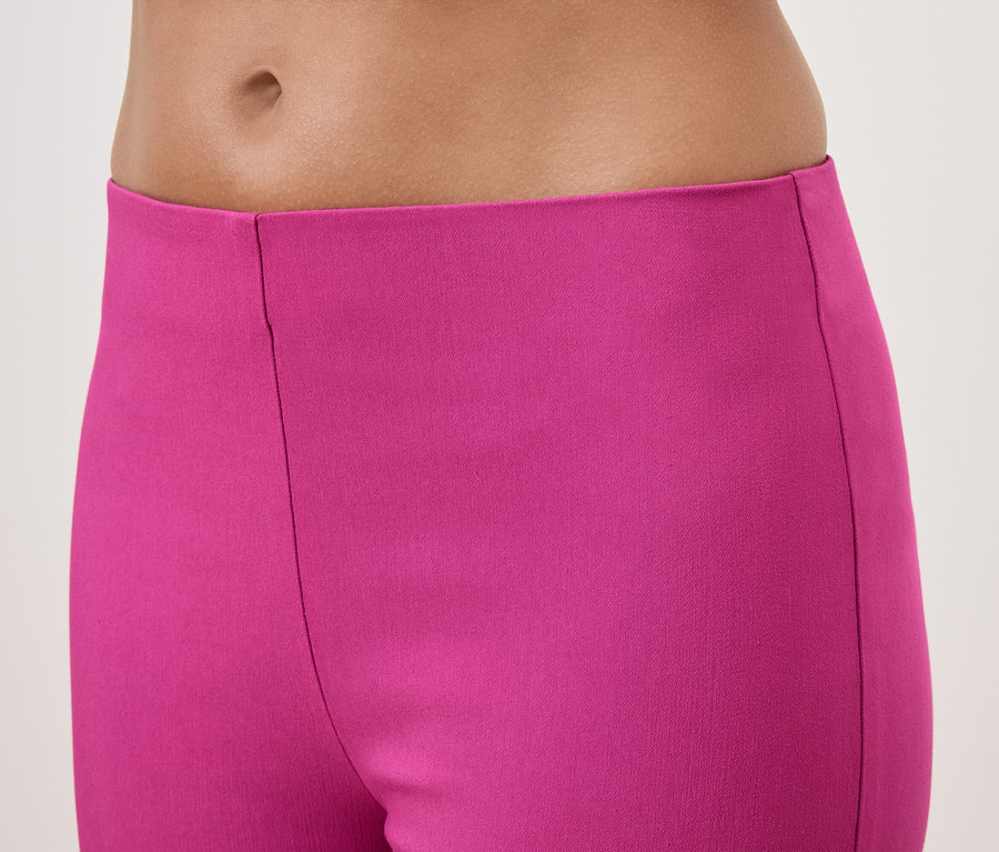 Gros plan du bas du corps d'une femme portant un pantalon rose.