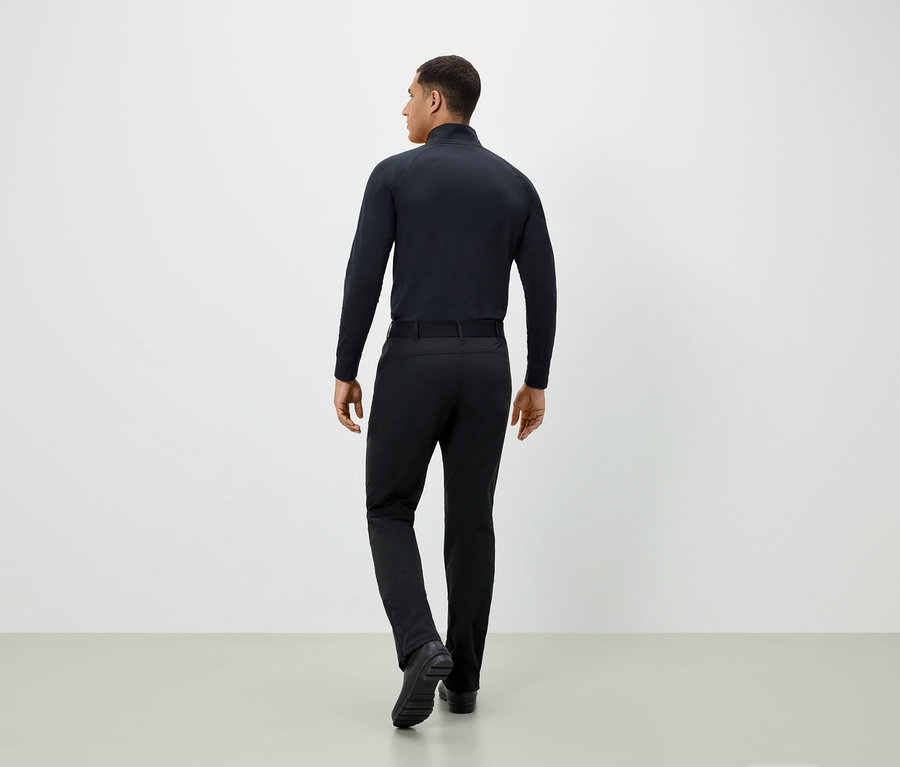 Homme en tenue noire, vu de dos.