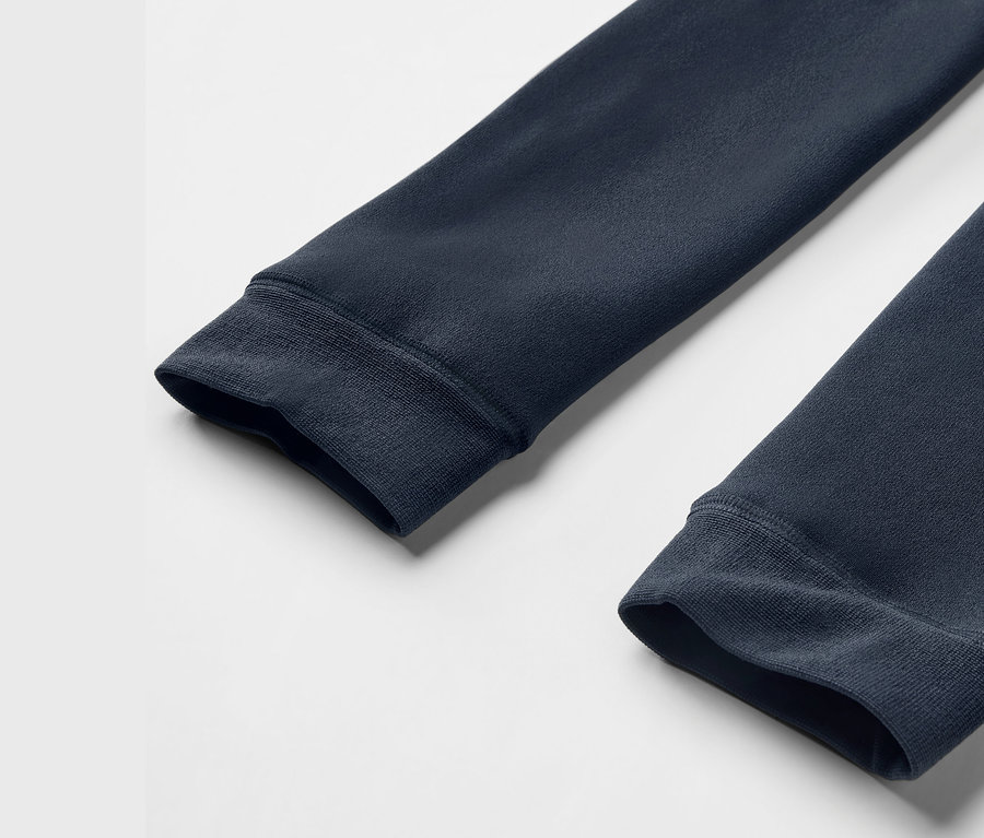 Gros plan sur les manches d'un sweat-shirt bleu marine avec poignets côtelés sur un fond blanc.