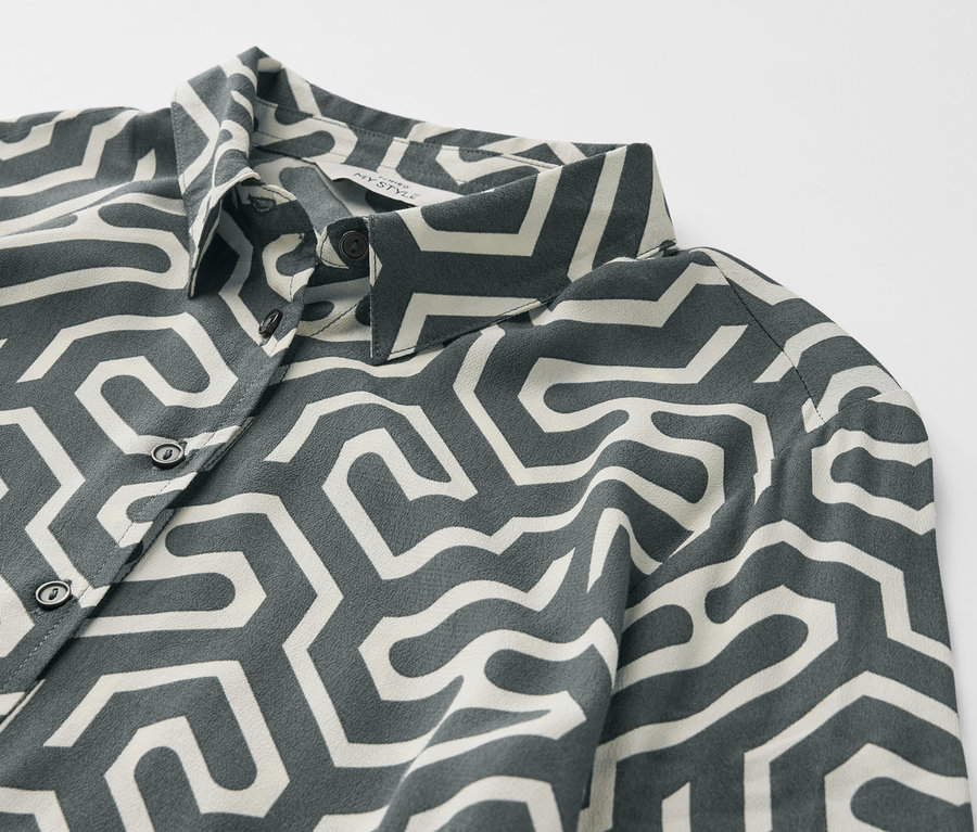 Gros plan sur une robe chemise imprimée avec un motif géométrique.