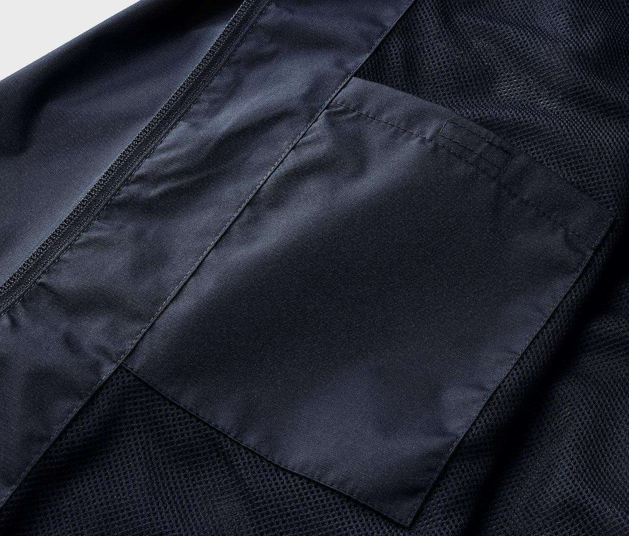 Détail d'une veste de pluie bleu marine avec poche.