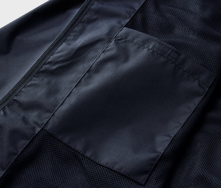 Détail d'une veste de pluie bleu marine avec poche.