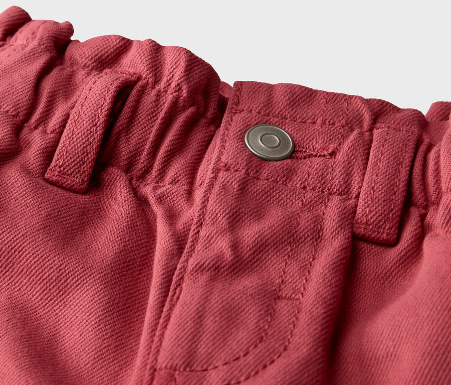 Détail d'un jean pour enfants – Coupe «	Greta	» avec bouton.
