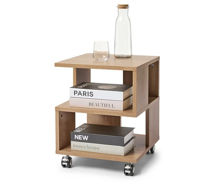 Sur un tabouret à roulettes marron clair se trouvent un verre, une bouteille avec un bouchon de liège et deux livres.